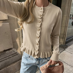 Solid-color crew-neck sweater with lettuce-edge trim and button detailing